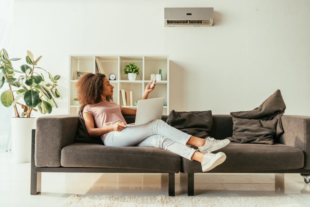 Hvac Woman Using Laptop And turning her AC on.