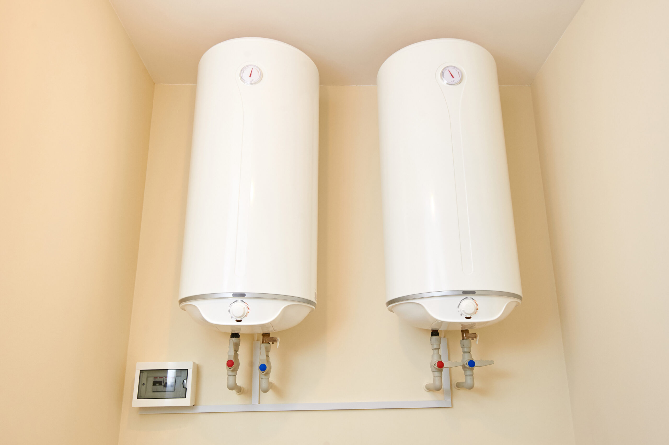 A hot water heater being repaired by a service worker.